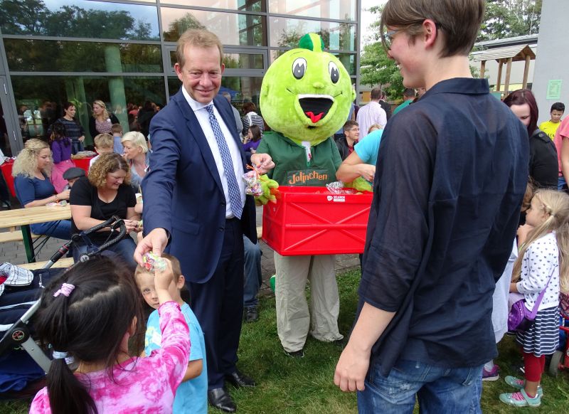 Als Dank an alle Kinder, die das Fest musikalisch eröffnet hatten, verteilten Bürgermeister Steffen Mues und „Jolinchen“ vom TV Jahn kleine Tüten mit Naschereien. (Foto: Stadt Siegen)