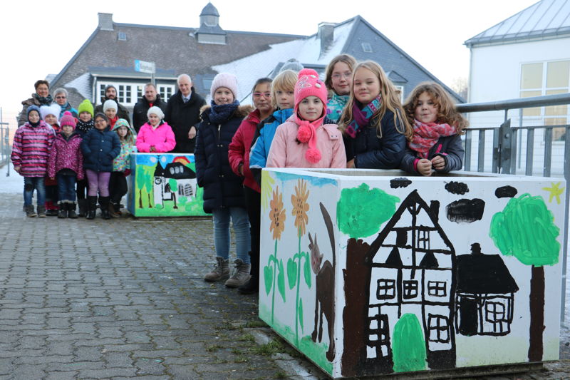 Die Kinder der OGS Burbach haben die Blumenkübel zwischen Turnhalle und Grundschule bunt bemalt. Im nächsten Jahr sollen darin Dahlien, Lilien und Gladiolen blühen. (Fotos: Gemeinde Burbach)